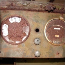 Rusted halftrack dashboard with two circular gauge openings and key switch