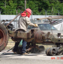 Worker sandblasting halftrack frame side view