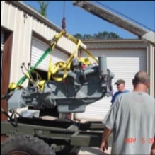 Crane hoisting engine above halftrack outdoors