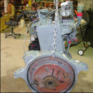 Rebuilt gray halftrack engine side view with red flywheel and chain