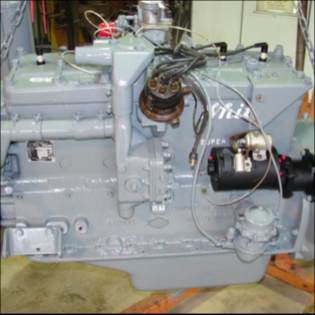 Rebuilt gray halftrack engine front view with wiring in shop